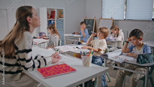 Obraz na płótnie Clever schoolchildren looking educator in classroom closeup. Teacher asking w salonie