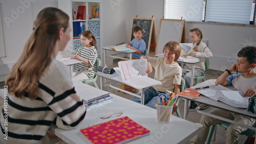 Obraz na płótnie Smiling teacher asking questions to kids in elementary school class room closeup w salonie