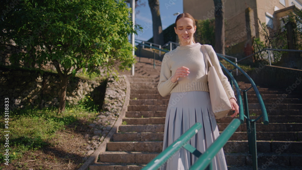 Happy teacher strolling staircase green trees nature. Romantic lady taking book