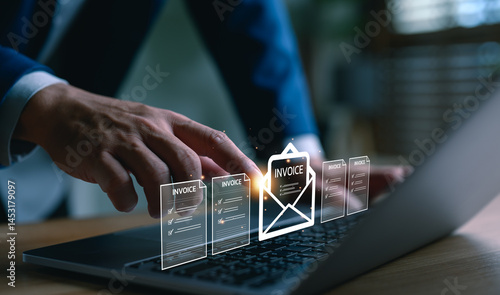 Businessman using laptop with digital invoice icons, representing e-invoicing, billing automation, financial technology, online payment, accounting software, ERP system, and paperless finance process.