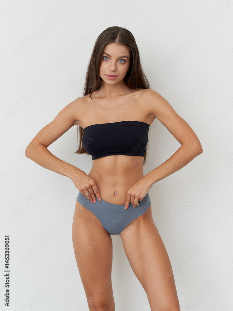Elegant pose of a female model showcasing modern fashion in a studio setting Elegant pose of a female model showcasing modern fashion in a studio setting