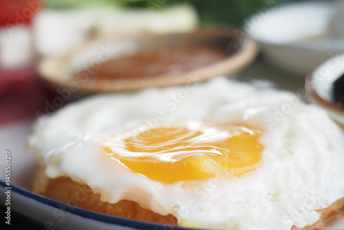 Canvas-taulu Fried egg with a runny yolk displayed on a vibrant breakfast plate