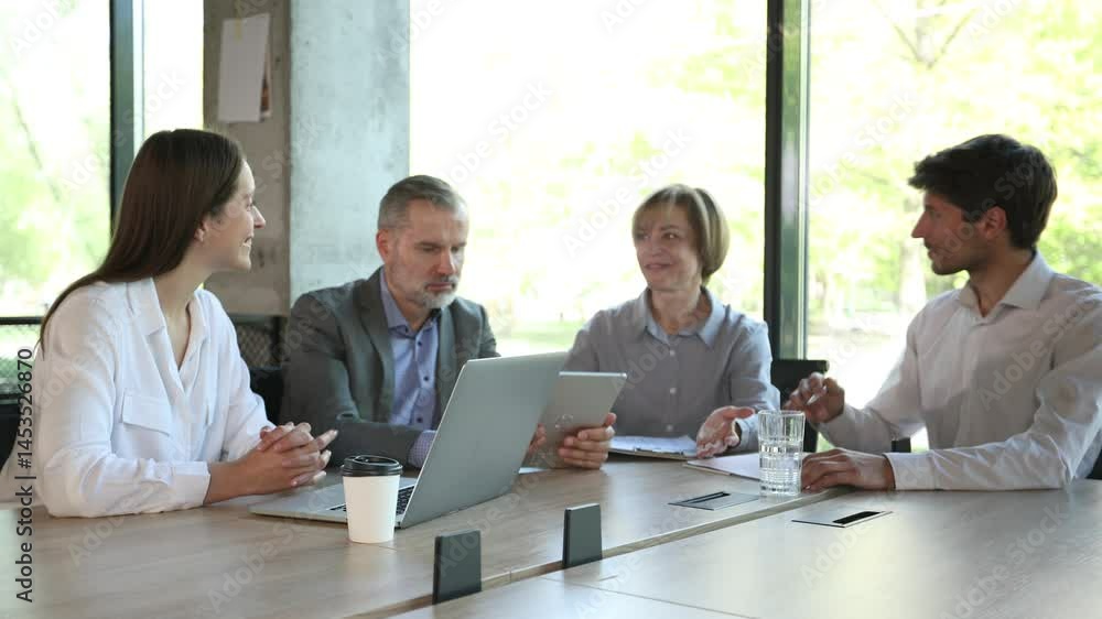 Business people discussing work together using a tablet and laptop taking notes in a modern office Business people discussing work together using a tablet and laptop taking notes in a modern office