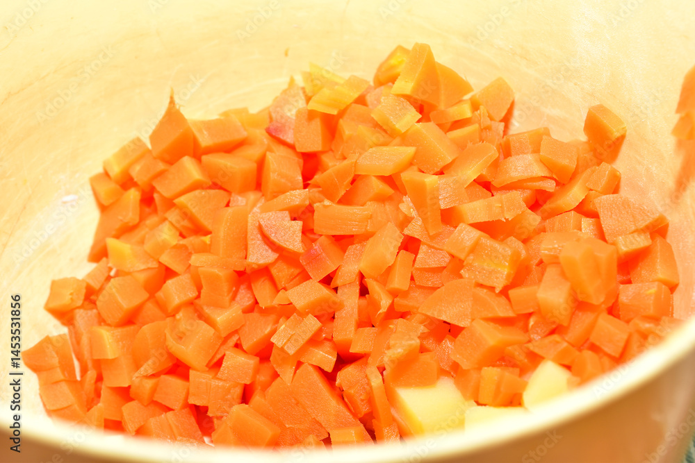 Finely chopped carrots for making the salad are placed in a deep bowl. Finely chopped carrots for making the salad are placed in a deep bowl.