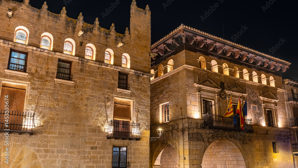 Monumental buildings in medieval style seen at night in the town of Valderrobles, Teruel.