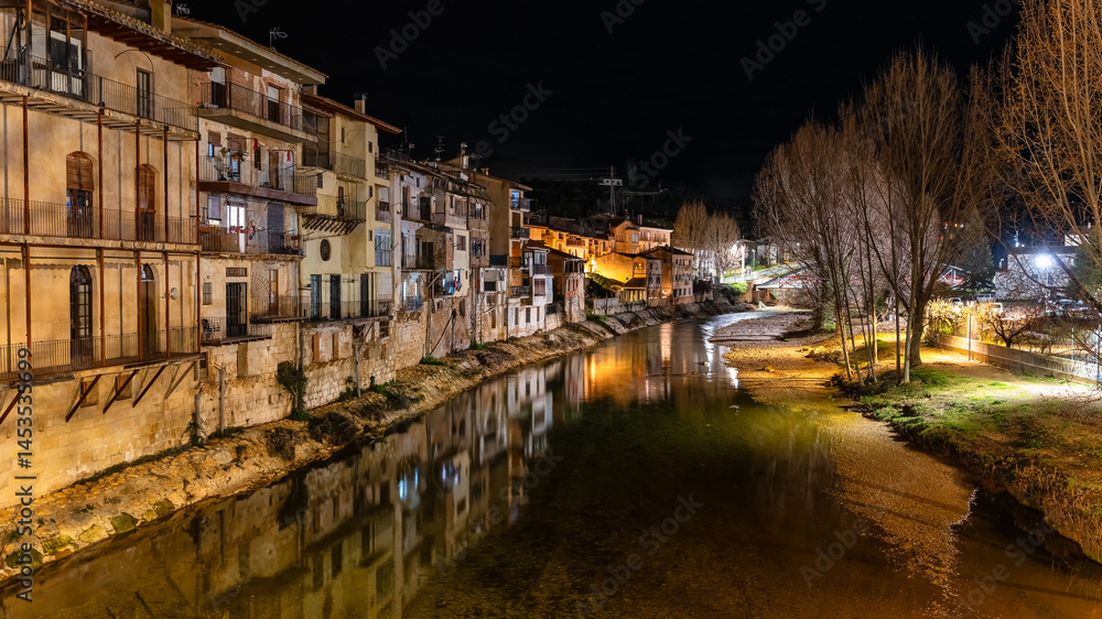Houses illuminated at night next to the river that passes next to the town of Valderrobles, Teruel, Matarrana.