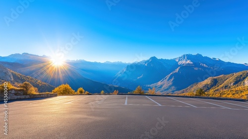 Empty parking lot panorama of mountain peaks at sunrise.