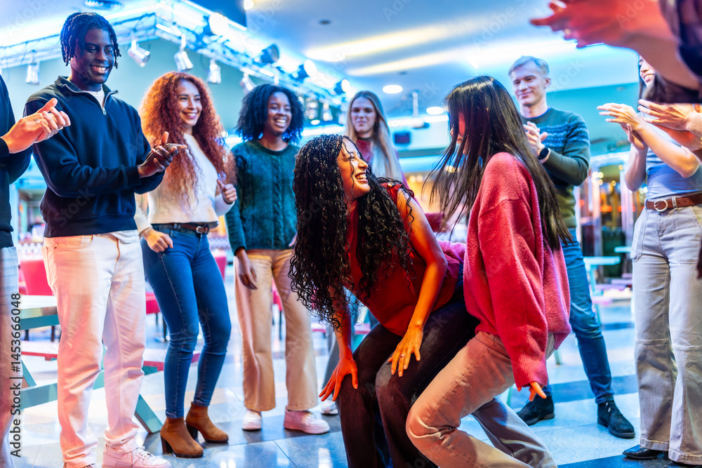 Multiethnic friends enjoying dance competition at bowling alley