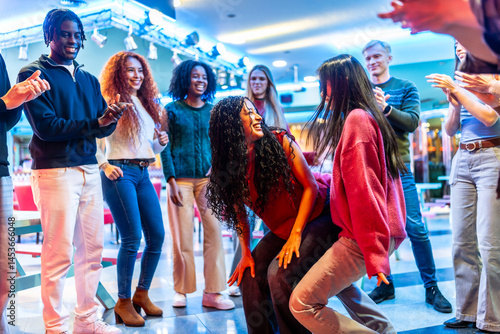 Obraz na płótnie Multiethnic friends enjoying dance competition at bowling alley w salonie