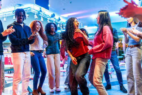 Obraz na płótnie Happy multiethnic friends dancing and enjoying time together at bowling alley w salonie