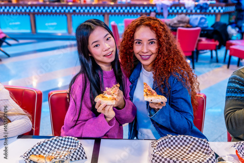 Obraz na płótnie Multiethnic female friends enjoying pizza at bowling alley restaurant w salonie