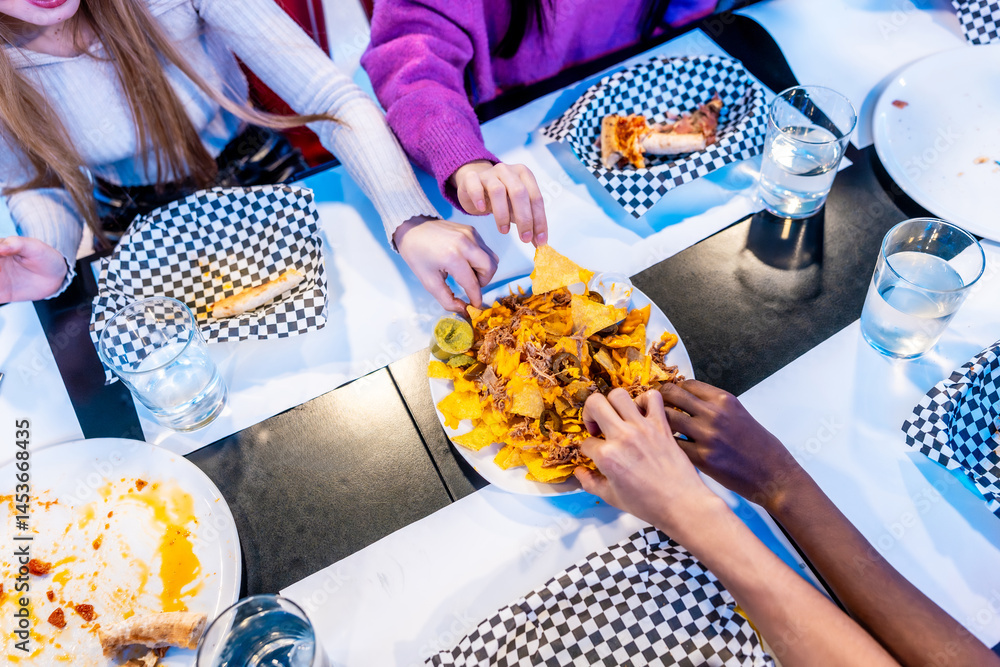Friends sharing nachos at a diner table, enjoying weekend fun
