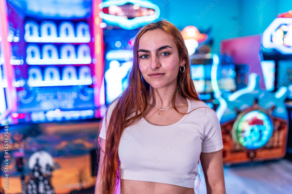 Young woman posing in an amusement arcade with neon lights