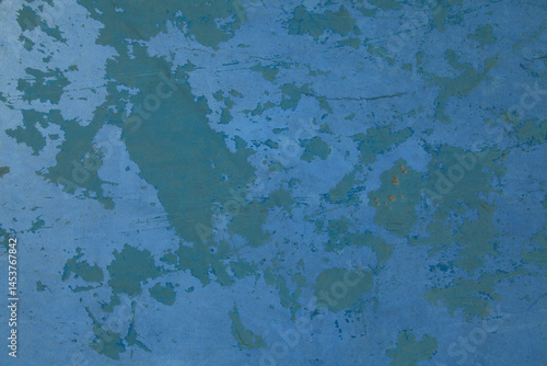 Blue concrete wall with old shabby coating. Smooth stone floor with remains of old blue paint. Self-leveling floor with blue peeling paint. Pale spotted background, texture. Surface with a blue tint