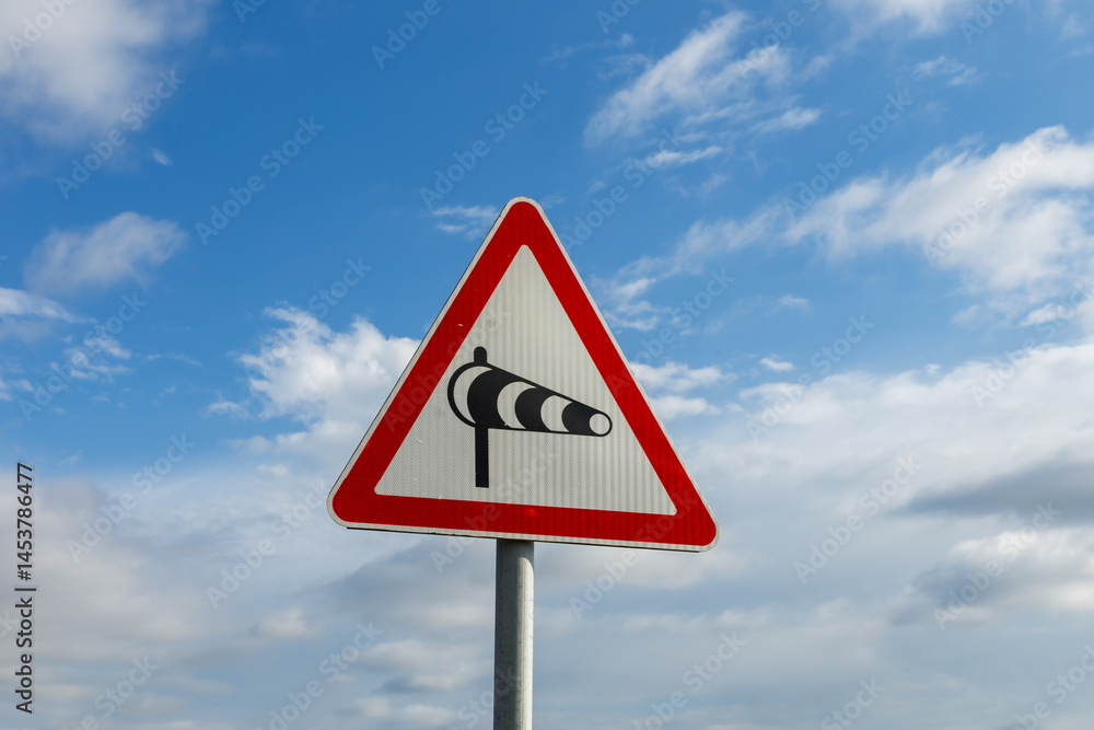 Crosswind caution sign warns drivers of potential hazards on roads during windy weather Crosswind caution sign warns drivers of potential hazards on roads during windy weather