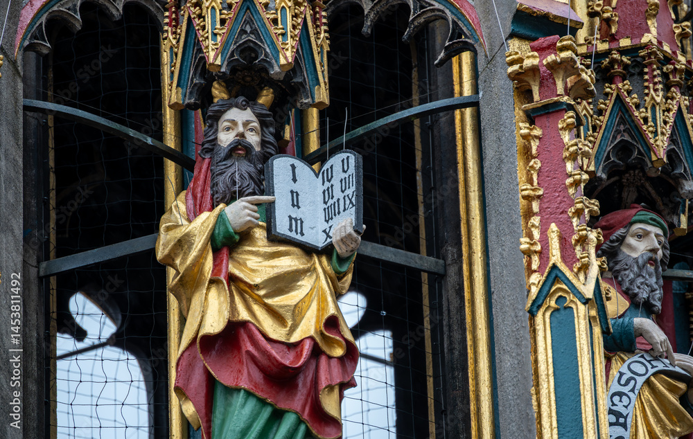 Fototapeta premium Nuremberg, Germany, August 2, 2023. Detail of one of the many statues that characterize the golden fountain in the market square. Travel destinations and tourist attractions.