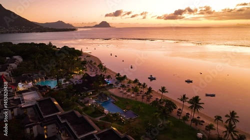 A dreamy twilight aerial of palm-lined resort nestled by the beach in beautiful Le Morne, Mauritius