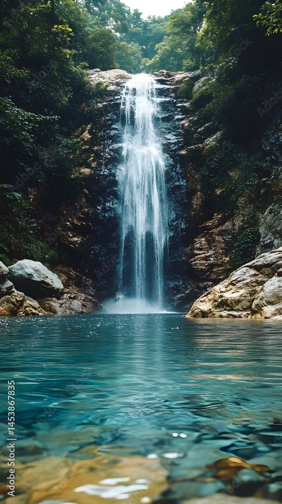 Naklejka premium Lush waterfall cascading into a tranquil pool, surrounded by dense greenery