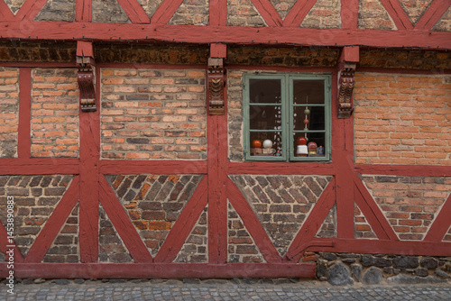 Close-up of traditional brick wall with timber frame and window in Ystad, Sweden.