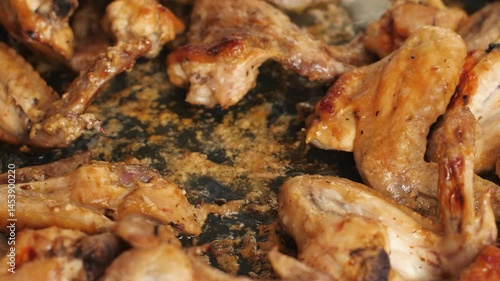 close up appetizing grilled chicken wings picked with fork from tray cooking fried chicken wings