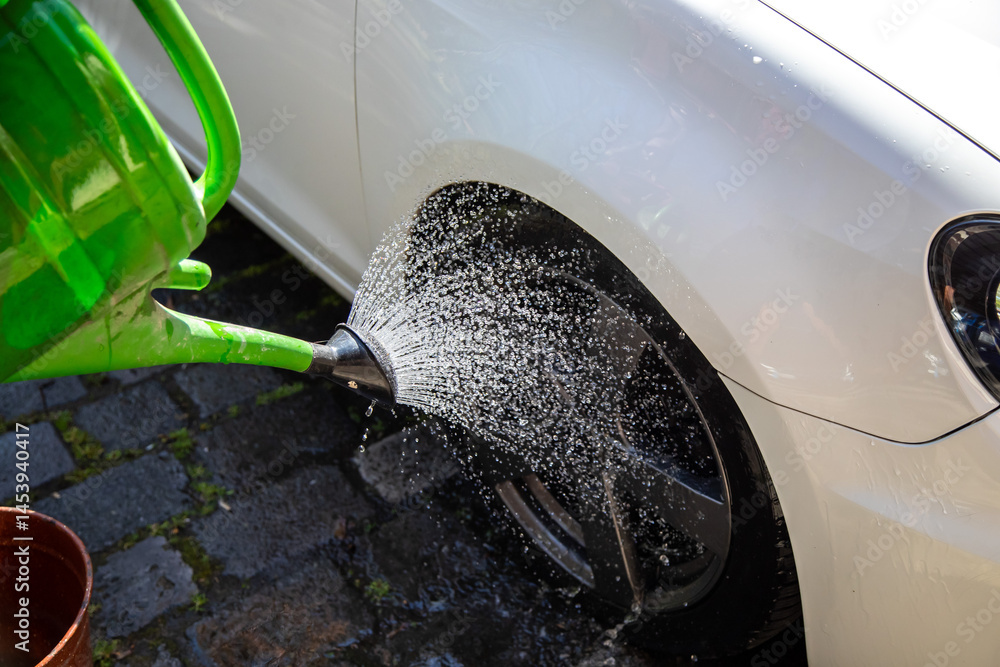 Rad abgießen mit Regenwasser aus einer Gießkanne