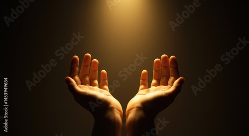 Two cupped hands reaching upwards against a dark background. A soft warm golden light emanates from above, gently illuminating the hands.