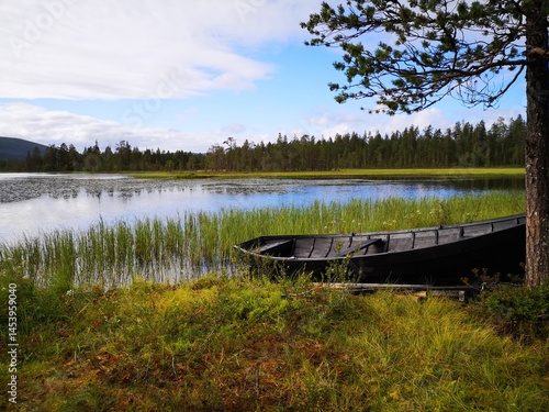 Black wooden boat on a finnish lapland lake