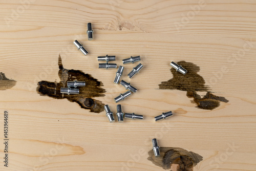 Obraz na płótnie metal rivets for furniture are used to install shelves in cabinets, furniture metal fittings on a wooden board, closeup w salonie