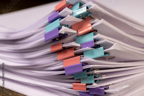 Obraz na płótnie sheets of paper are connected by multicolored clips, stacked sheets of paper for documents are joined together w salonie