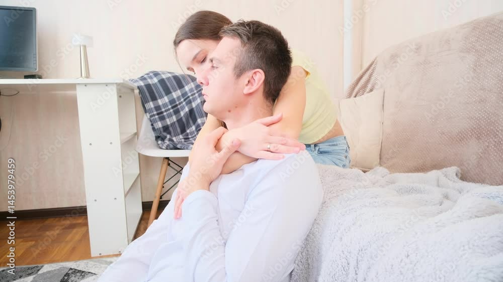 Couple in love sitting and hugging in the living room at home Couple in love sitting and hugging in the living room at home