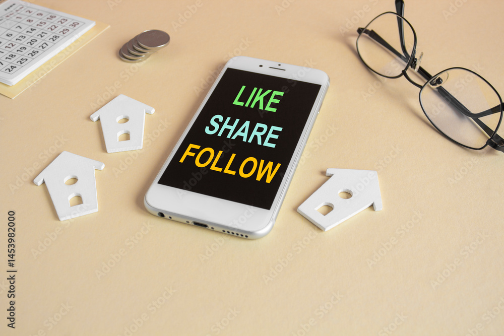 The expression Like share follow written on the mobile phone screen. Beautiful beige background. Glasses, miniature houses, coins. Business concept.