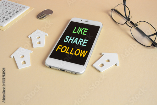 Obraz na płótnie The expression Like share follow written on the mobile phone screen. Beautiful beige background. Glasses, miniature houses, coins. Business concept. w salonie