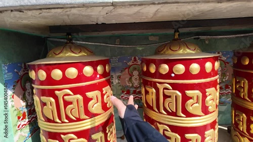 4k video footage of A woman is spinning Nepalese prayer wheels at Annapurna Base Camp (ABC) Trek. Blessing Buddhist writings with nepali characters on the wheel surface