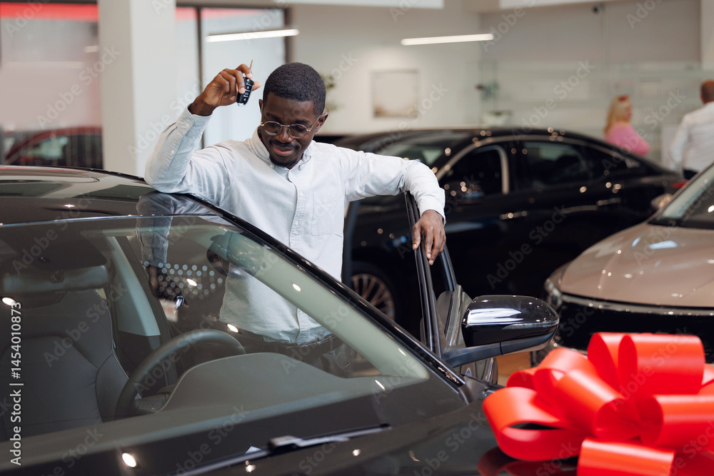 Young male African businessman hold key and buy car in dealership store. Sales automobile showroom concept. Young male African businessman hold key and buy car in dealership store. Sales automobile showroom concept.