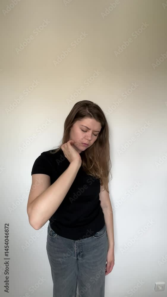 Portrait of a woman in casual clothes holding her neck with a pained expression. Physical discomfort, fatigue, stress, poor posture symptoms, neck pain Portrait of a woman in casual clothes holding her neck with a pained expression. Physical discomfort, fatigue, stress, poor posture symptoms, neck pain