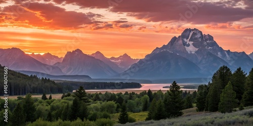 Fototapeta Naklejka Na Ścianę i Meble -  Grand teton mountains at sunset with trees and river in the foreground and orange sky above it all