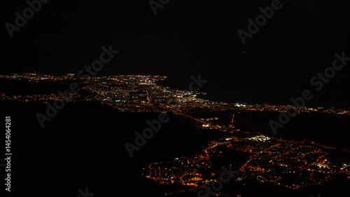 Aereal shot of Tenerife by night with city lights and traffic cars passing by filmed from a mountain top in Adeje. South Tenerife, Canary island, Spain