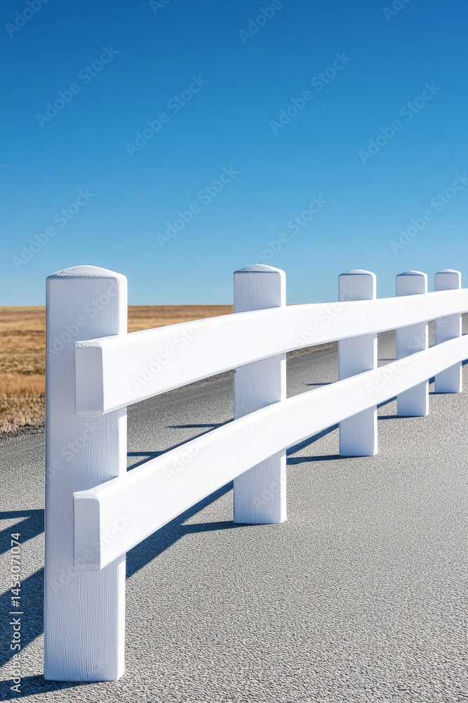 A bright white fence contrasts with a clear blue sky in a serene landscape setting. A bright white fence contrasts with a clear blue sky in a serene landscape setting.