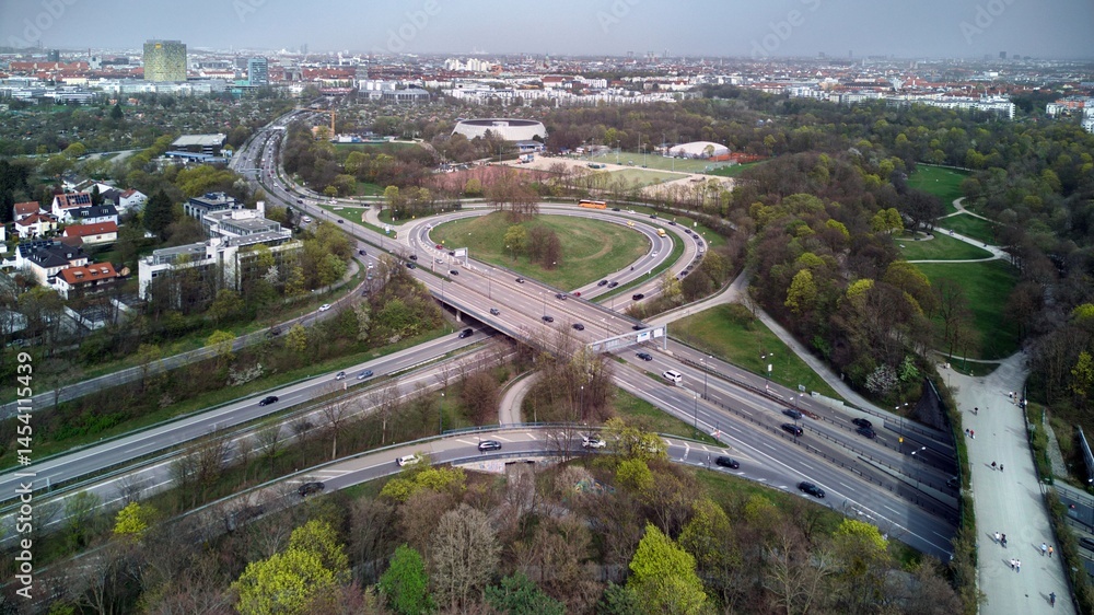 Fototapeta premium View of Westpark and part of Munich city from above. A cloudy day, a gray horizon. Aerial drone shot. Trees and bushes are still partially leafless. Spring has arrived.