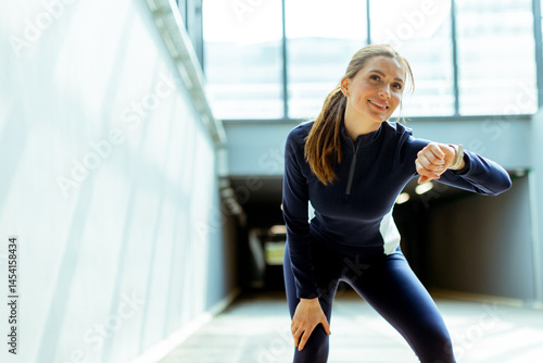 Motivated athlete taking a break while training indoors in a bright, modern gym environment