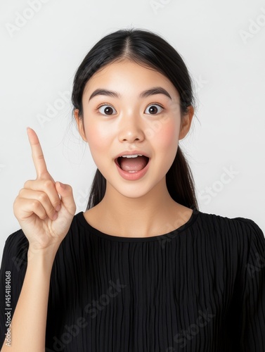 A beautiful young asian woman with a pinky finger raised, indicating something confidential or surprising.