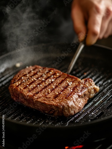 Obraz na płótnie Hand grilled steak cooking with visible grill marks and a searing flame. w salonie