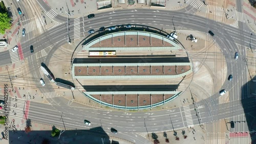 Aerial top view of modern tram station on large urban roundabout with traffic and pedestrians. public transport interchange hub