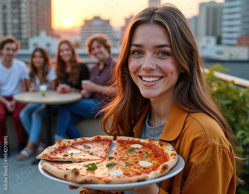 Wallpaper Mural Young woman smiling and holding a pizza while sitting with friends on a rooftop at sunset. Torontodigital.ca
