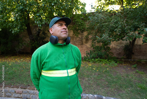 A man wearing a green sweatshirt and headphones