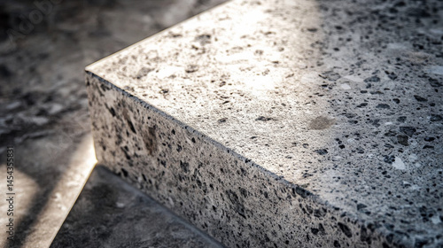 A close-up of a speckled stone tabletop, where the dance of light and shadow creates a timeless, natural design