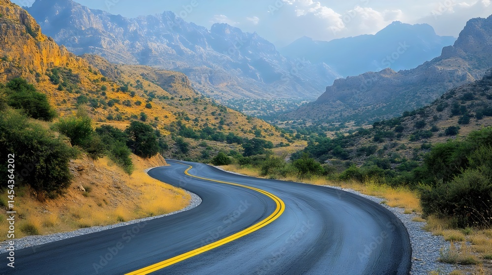 Fototapeta premium A captivating view of a winding road through majestic mountains under a clear blue sky.