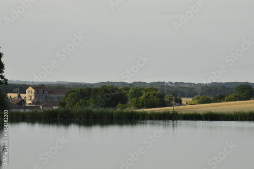 Reflet du ciel bleu dans le grand étang de retenue près du bourg de Champagne au Périgord Vert 