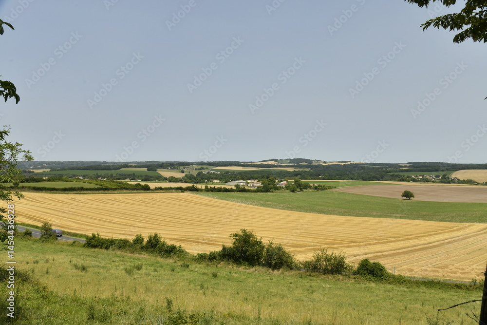 Obraz premium Lignes dans un champ de blé après moisson au pied de la colline du château médiéval à Villebois-Lavalette en Charente 