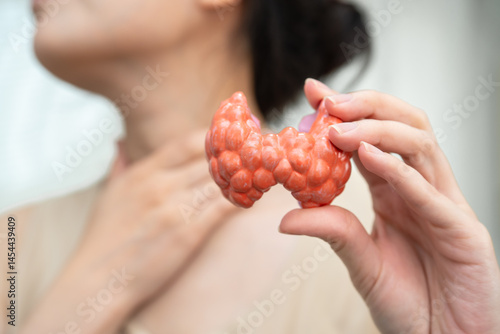Hyperthyroidism, Overactive Thyroid, Thyroid Lymphoma, Asian woman with thyroid gland human anatomy model.
